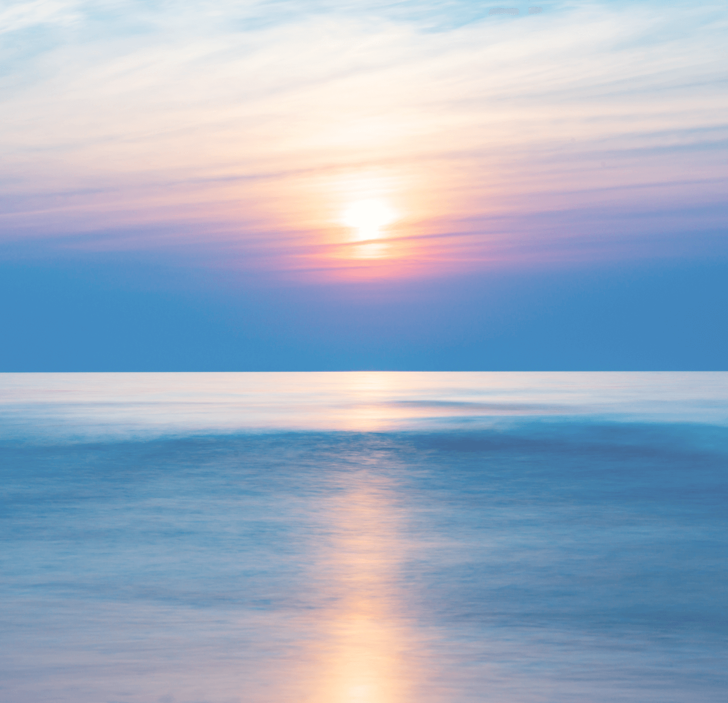 海の水平線上に沈みかけた夕日が幻想的に輝く風景